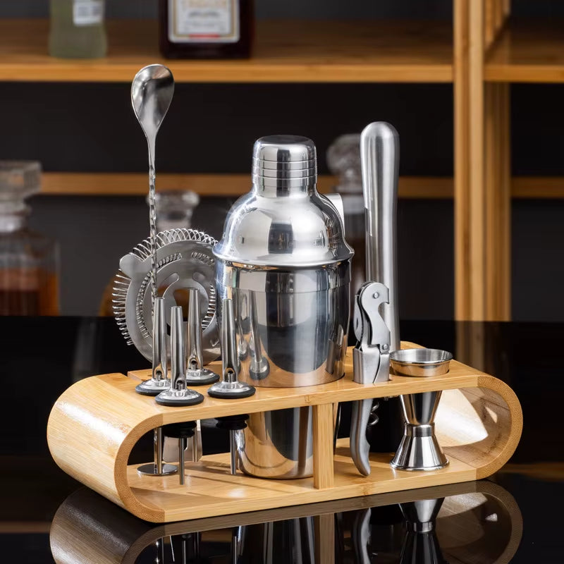 Stainless steel cocktail shaker set with tools on wooden stand, ideal for home or professional bar use.